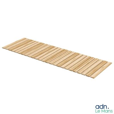 La planche de bois est posée sur le sol, à côté du fond blanc.