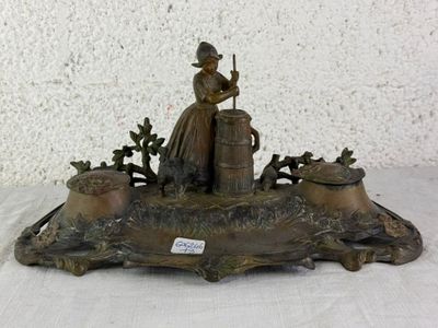 a bronze statue of a woman with a basket of flowers