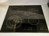 a black stove top with four burners on it