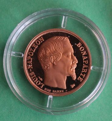 a close up of a coin in a clear holder on a green surface