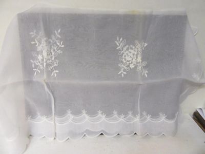une nappe blanche ornée de fleurs blanches, avec une paire de ciseaux à côté