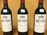 trois bouteilles de vin posées sur une table l'une à côté de l'autre