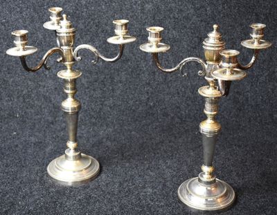 pair of antique silver plated candelabs on black background