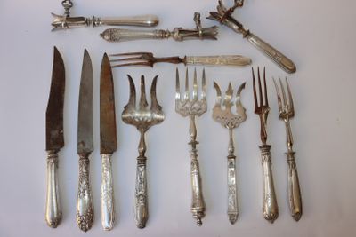 tout un service d'argenterie sur une table, comprenant un couteau, une fourchette, une cuillère et un repose-couteau