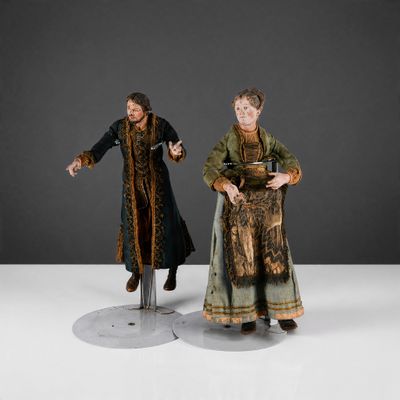 two figurines of a man and a woman dressed in medieval clothing