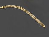un bracelet à chaîne en or avec un fermoir sur fond noir