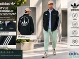 un homme qui marche dans la rue, vêtu d'une veste et d'un chapeau