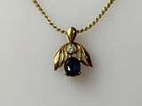 a close up of a necklace with a blue stone on it