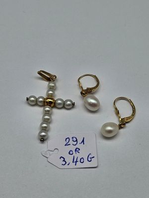 two pairs of pearl earrings and a cross on a white surface