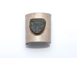 un gros plan d'une bague en argent sertie d'une pierre verte