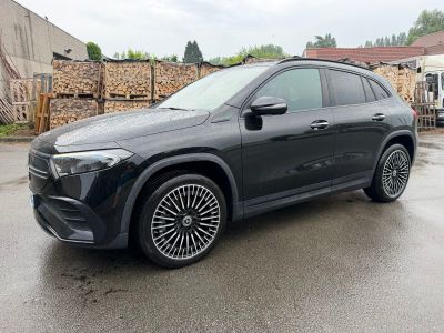 a black mercedes suv parked in a parking lot next to a building