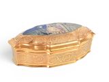 a gold box with a picture on it on a white surface
