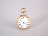 une petite montre de poche en or avec des chiffres romains