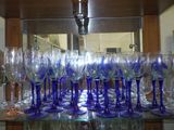 many wine glasses on a glass shelf in a room