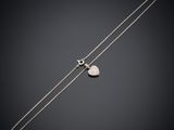 un collier en argent orné d'un pendentif en forme de cœur sur fond noir