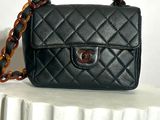 a small black bag with a chain hanging from it