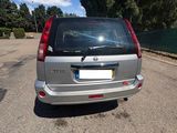 the back end of a silver minivan parked in a parking lot