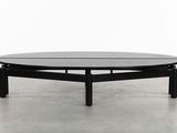 a black coffee table with a black top on a concrete floor