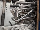 many wrenches and other tools in a metal box