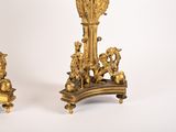 two gold vases sitting next to each other on a white surface