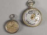 Deux types différents de montres de poche sont présentés sur une surface grise