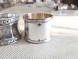 two silver cups sitting on a table next to each other