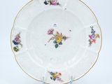 a white plate with flowers on it on a stand