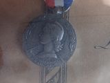 a silver medal with a red, white, and blue ribbon on it