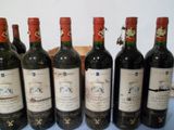 six bouteilles de vin sont alignées sur une table bleue