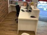 a desk with a chair and a computer on it in a room with a brick wall