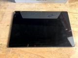 a black tablet computer sitting on a table next to a box