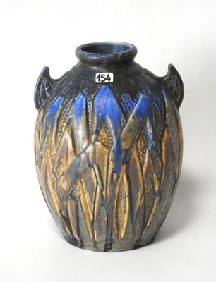 a blue and brown vase sitting on a white surface