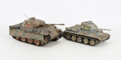 two toy tanks sitting next to each other on a white surface