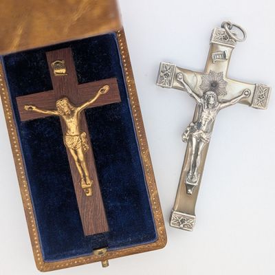 une croix en argent et un crucifix en bois dans un écrin