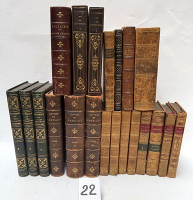 several old books stacked on top of each other on a white surface