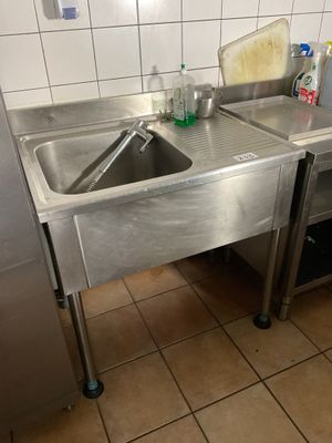 a stainless steel sink and a refrigerator in a kitchen