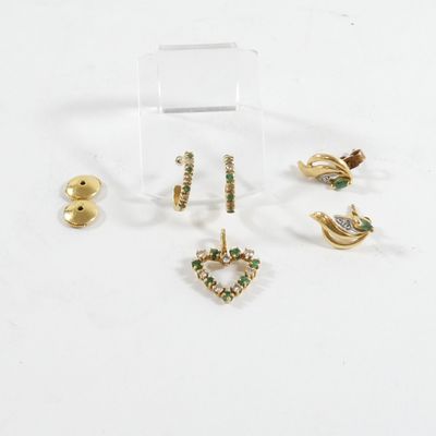 trois paires de boucles d'oreilles et une broche posées sur un fond blanc