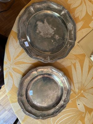 deux assiettes en argent posées sur une table recouverte d'une nappe jaune