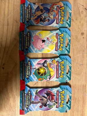 four packs of pokemon trading cards on a wooden table