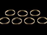 a group of six gold rings on a black background