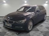 une photo d'un break BMW noir garé dans un garage