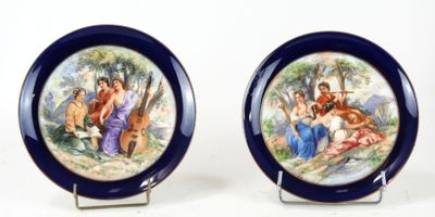 paire d'assiettes bleues et blanches ornées d'une peinture représentant un groupe de personnes