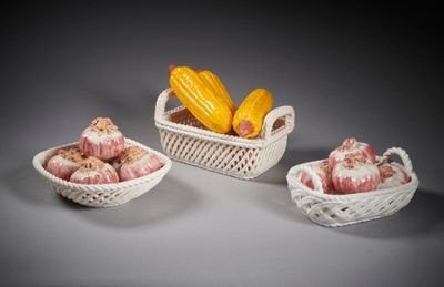 trois paniers blancs remplis de différents types d'aliments, posés sur une table