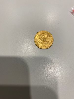 une pièce d'or posée sur une table blanche