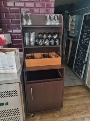 une cuisine équipée d'un réfrigérateur et d'une étagère sur laquelle sont posés des verres