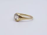a close up of a gold ring with a white diamond