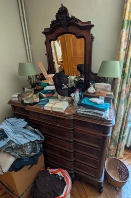 une commode avec un miroir et beaucoup de vêtements dessus
