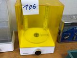 une petite machine jaune posée sur une table à côté d'un récipient en plastique