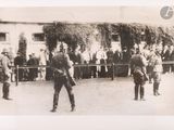 a black and white photo of a group of men standing in front of a building