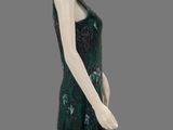 an image of a mannequin wearing a green dress with flowers on it